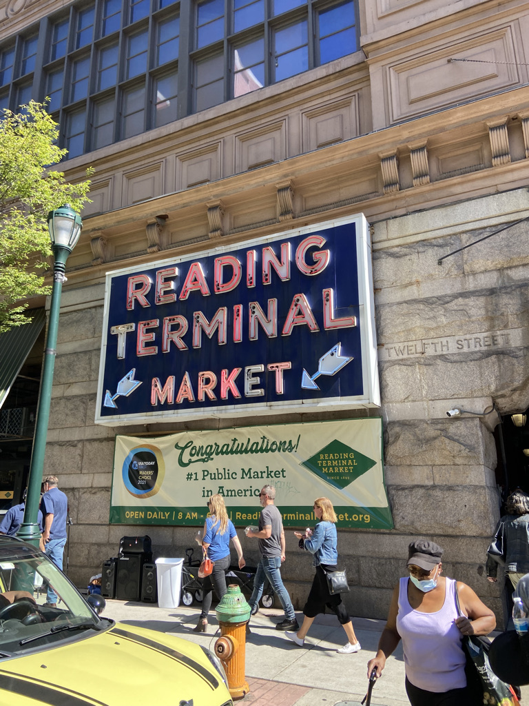 A sign that says "Reading Terminal Market" with a banner below it that says "Congratulations! Number one public market in America"