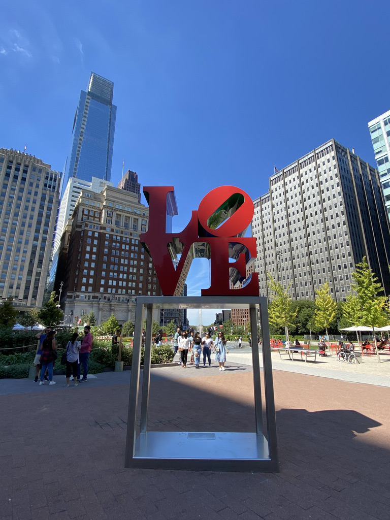 The LOVE sculpture with tall buildings in the background.