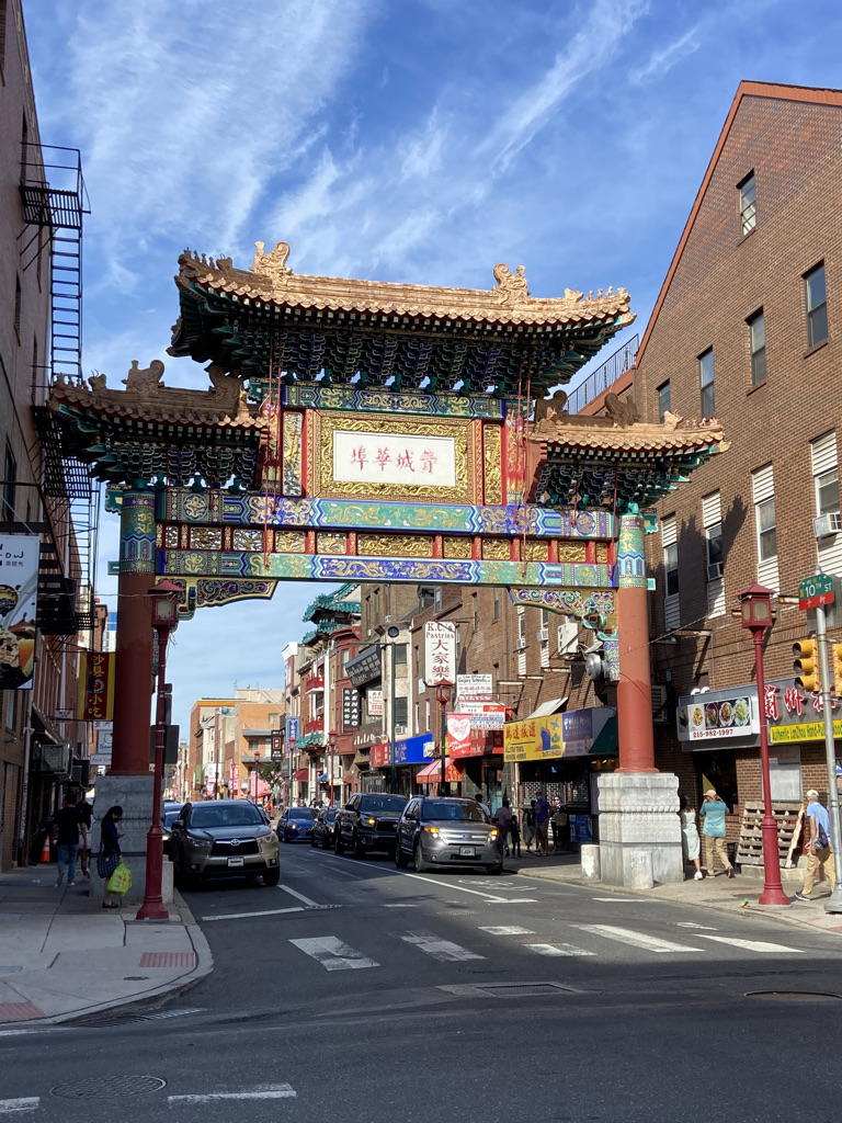The Friendship Arch in Chinatown - a gold, red, purple, and green Oriental-style arch decorated with Chinese symbols in the center. A street runs through the middle of the arch.
