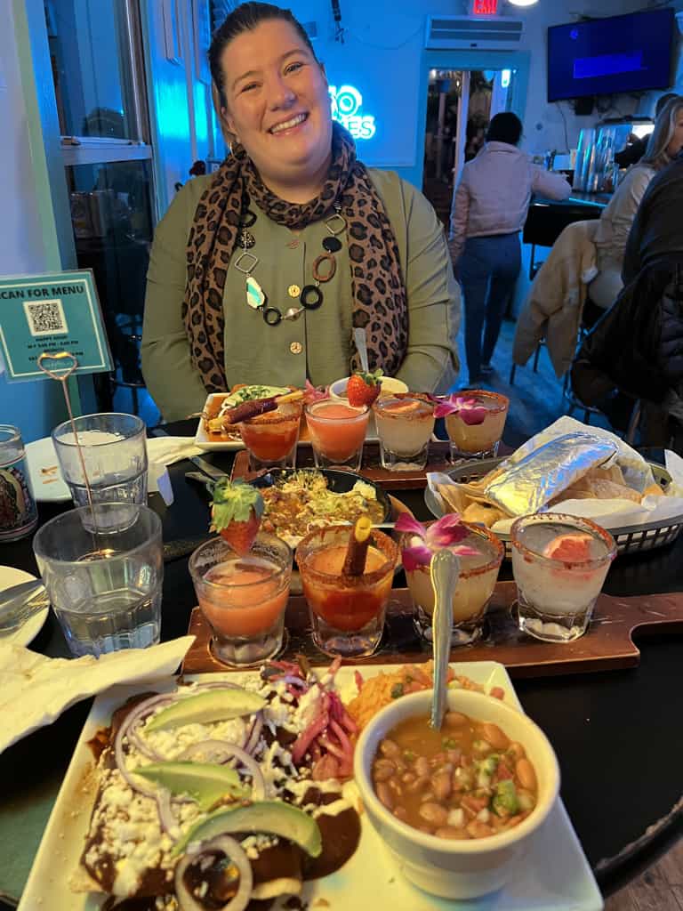 A girl that the author of this blog met at a hostel sitting at a table filled with Mexican food and margaritas.