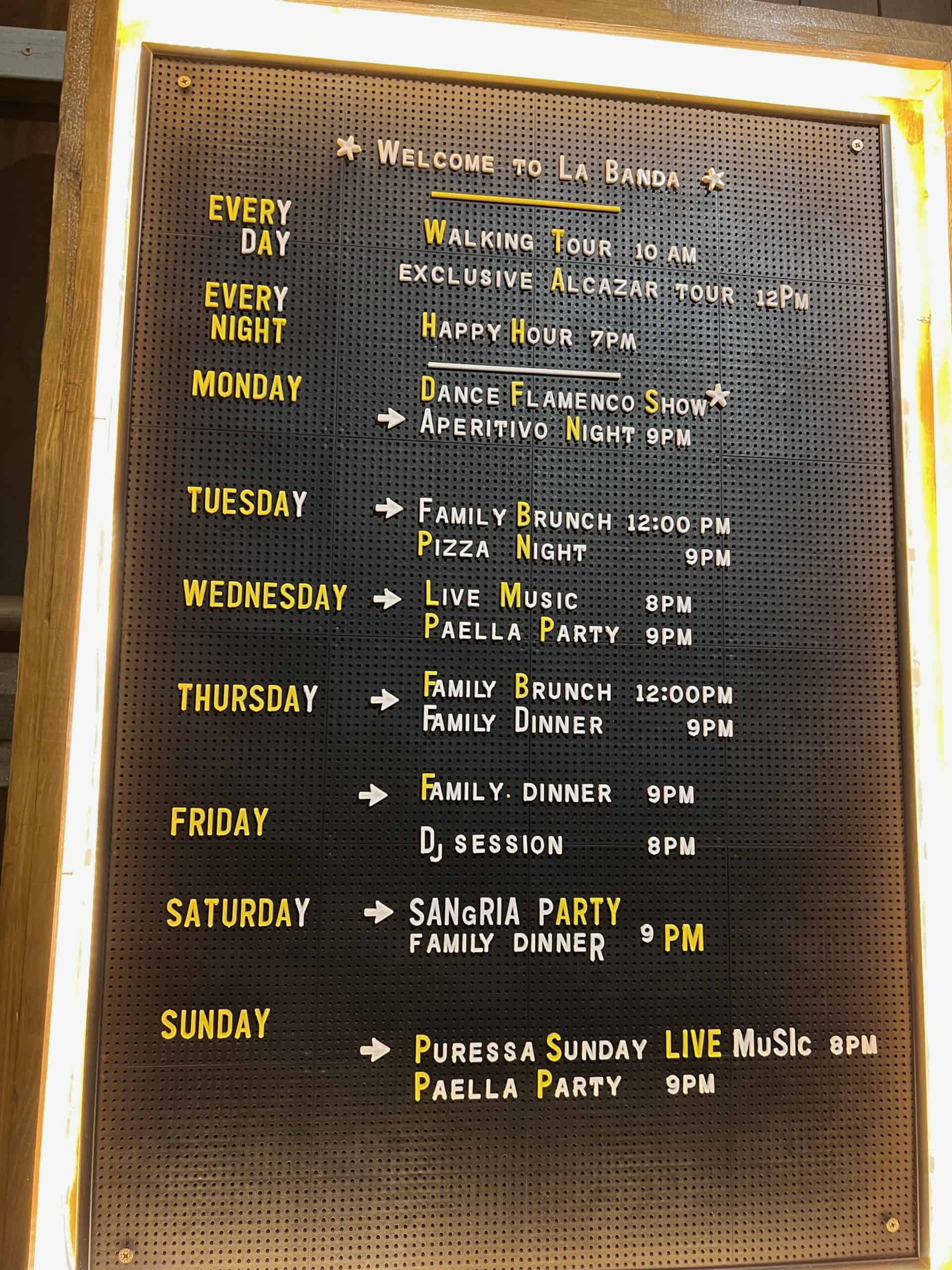 A board listing the weekly activities scheduled at a hostel in Seville, Spain